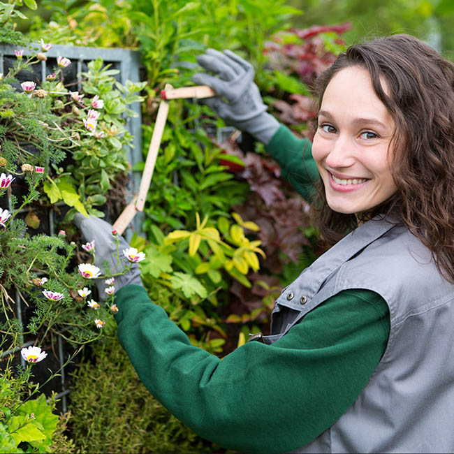Young attractive landscaper woman working in a public park